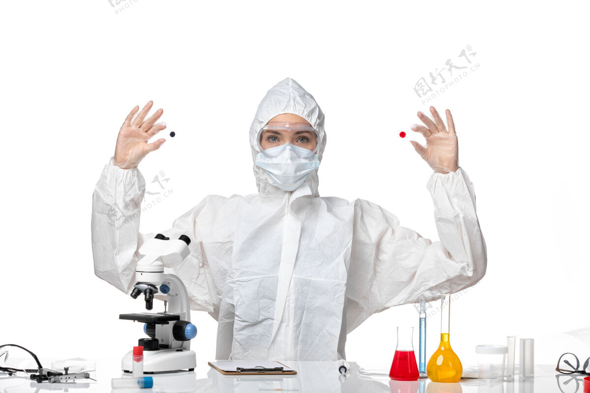 医疗正面图年轻女医生穿着白色防护服 戴着口罩 由于科维德工作在浅白色背景下大流行病毒健康科维德-病毒防护年轻女性