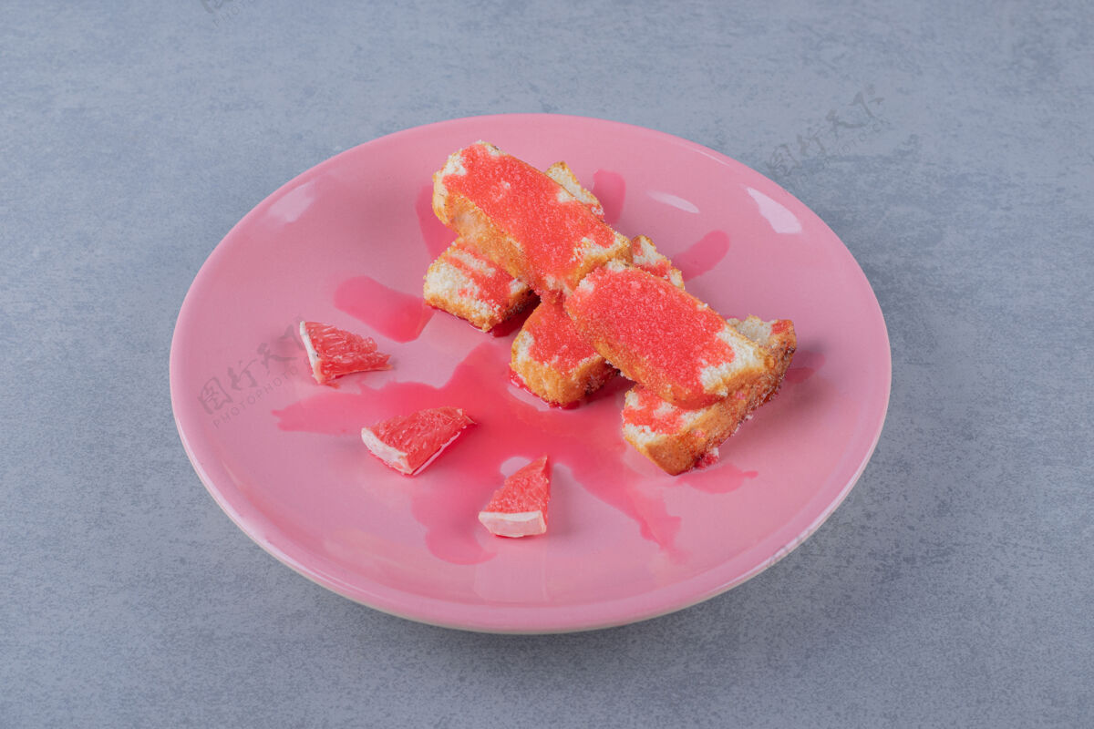 自制新鲜出炉的蛋糕和葡萄柚片放在粉红色的盘子里填充烹饪糕点