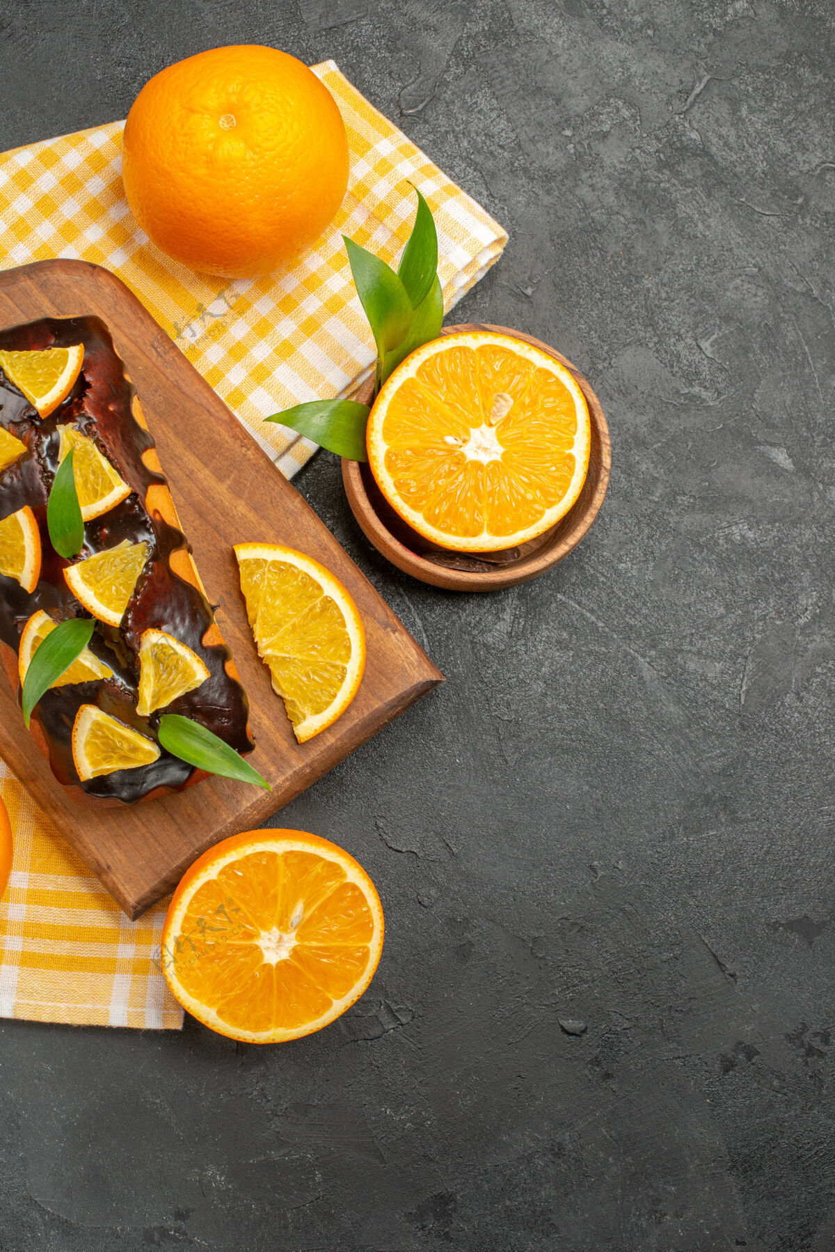 可食用水果整个软蛋糕和切好的柠檬叶在深色桌子上的垂直视图水果酸橙餐桌