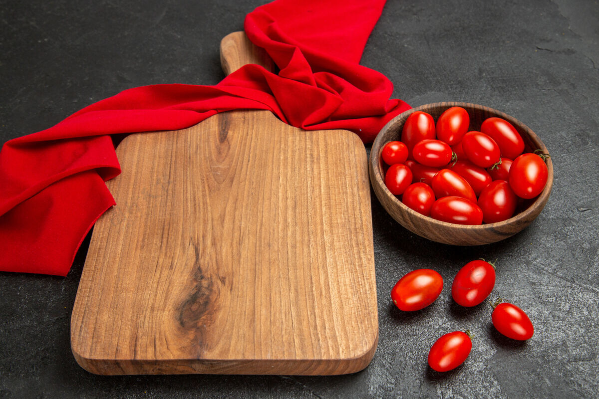 新鲜底部视图碗与樱桃番茄红毛巾砧板和樱桃番茄在黑暗的背景板黑底部