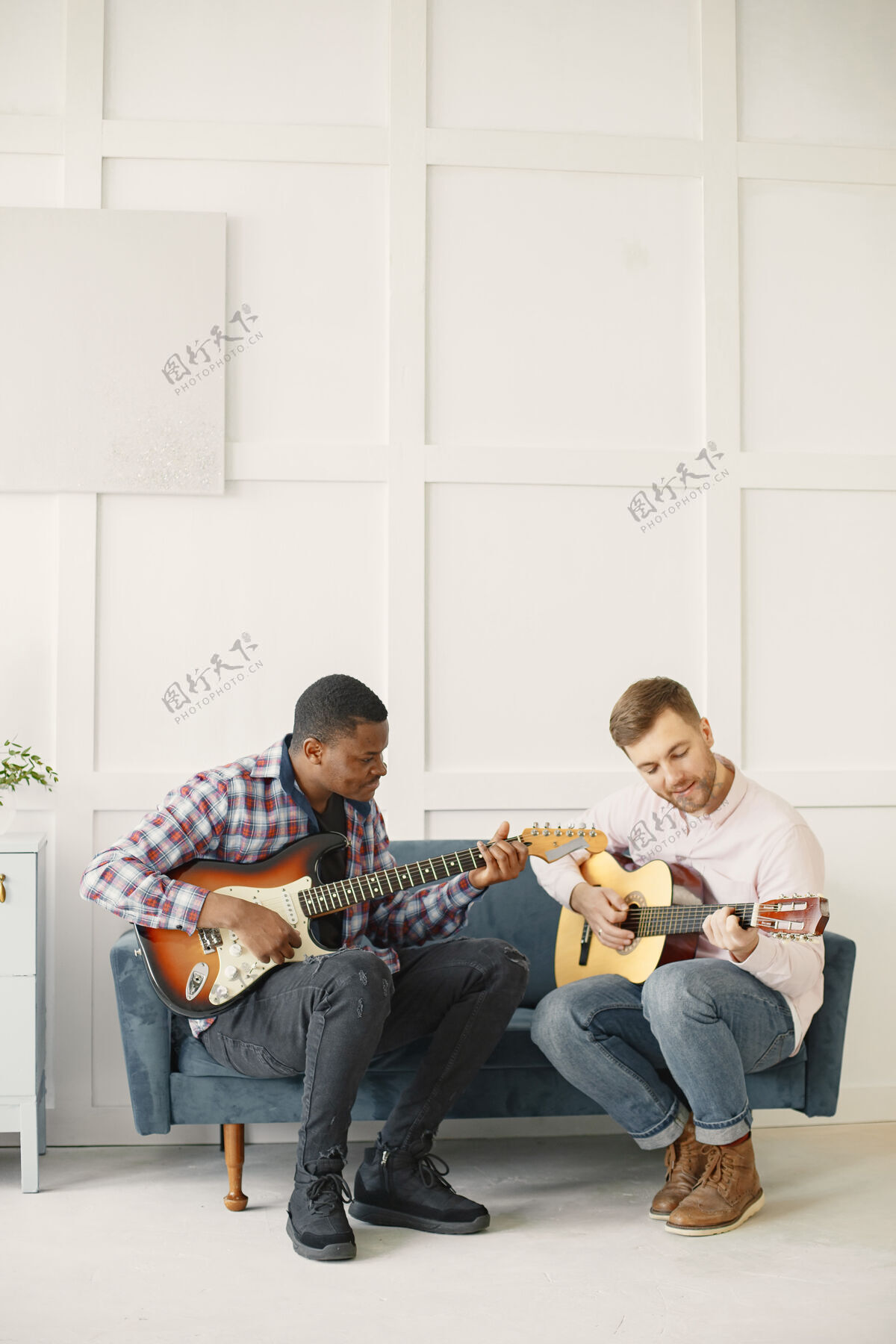 滚动男人弹吉他 写音乐 非洲和高加索男人年轻男性旋律