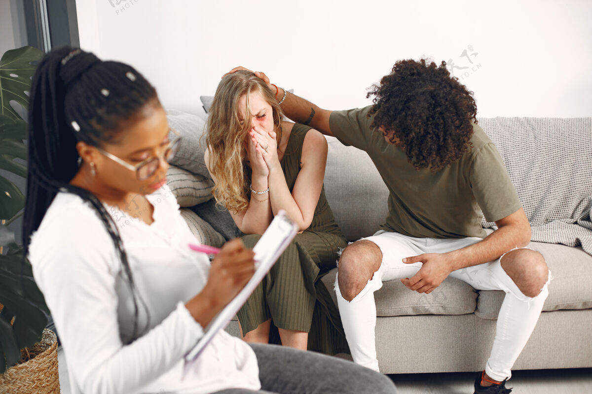 顾问心理学家的一对年轻夫妇和他们的治疗师讨论关系问题写作离婚家庭