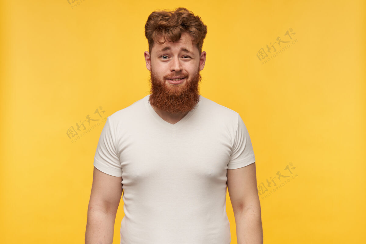 学生一个尴尬的年轻人 留着大胡子 穿着一件空t恤 感到困惑和不快没刮胡子不满意情绪