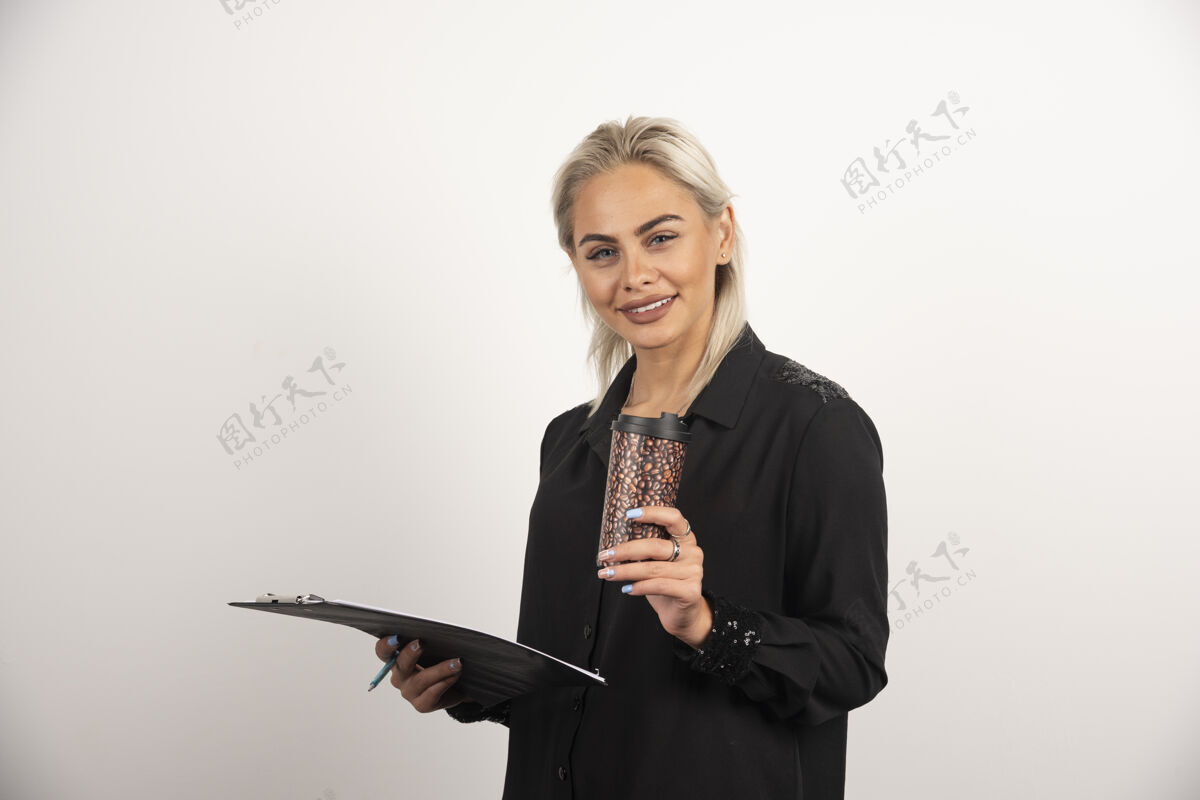 年轻人正面的女人摆着一个杯子和剪贴板在白色背景上高质量的照片杯子人人类