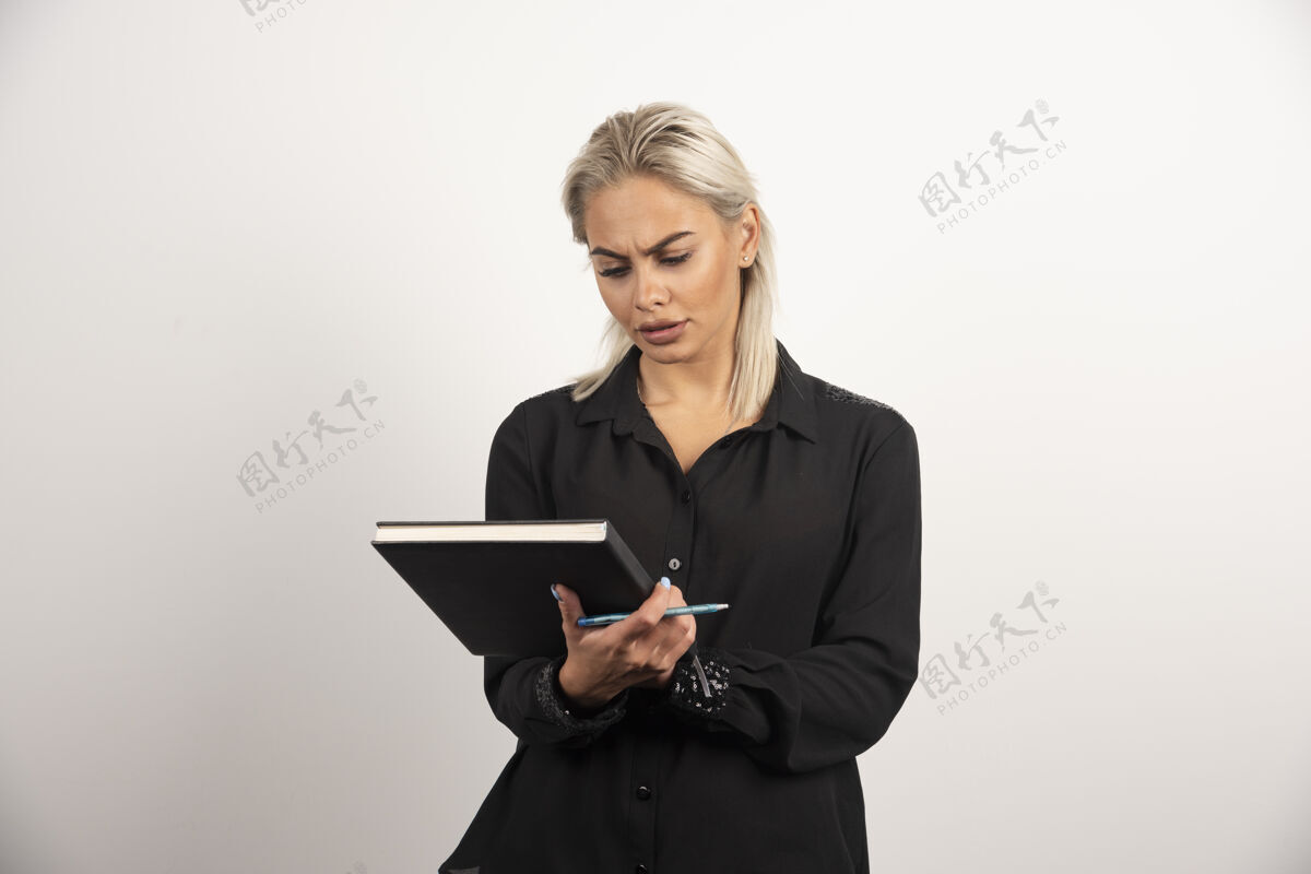 女人严肃的女人用铅笔在白色背景的剪贴板上看高质量的照片人铅笔剪贴板