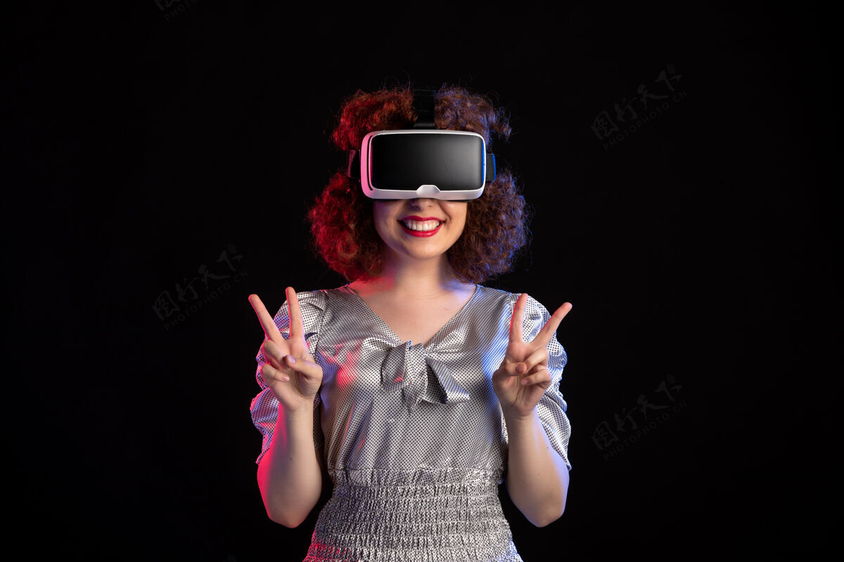 视觉年轻女性戴着虚拟现实耳机在黑暗的表面女性女人年轻女性