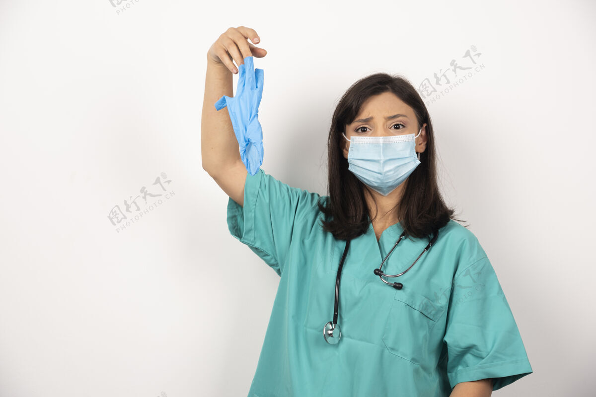 职业戴着口罩的女医生拿着白色背景的手套高质量的照片手套持有面罩
