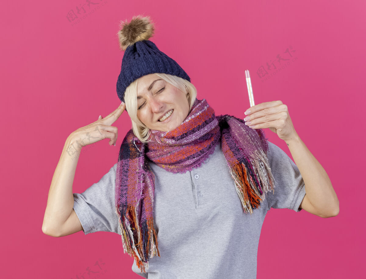 年轻未被释放的年轻金发病斯拉夫妇女戴冬季帽子和围巾手势标志围巾太阳穴金发
