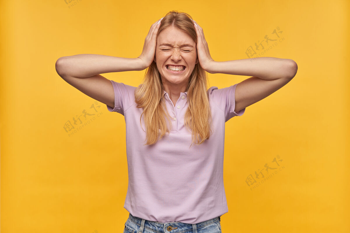 侵略性穿着薰衣草T恤的有雀斑的压力紧张的女人手放在头上 头上有黄色的头痛姿势模特手