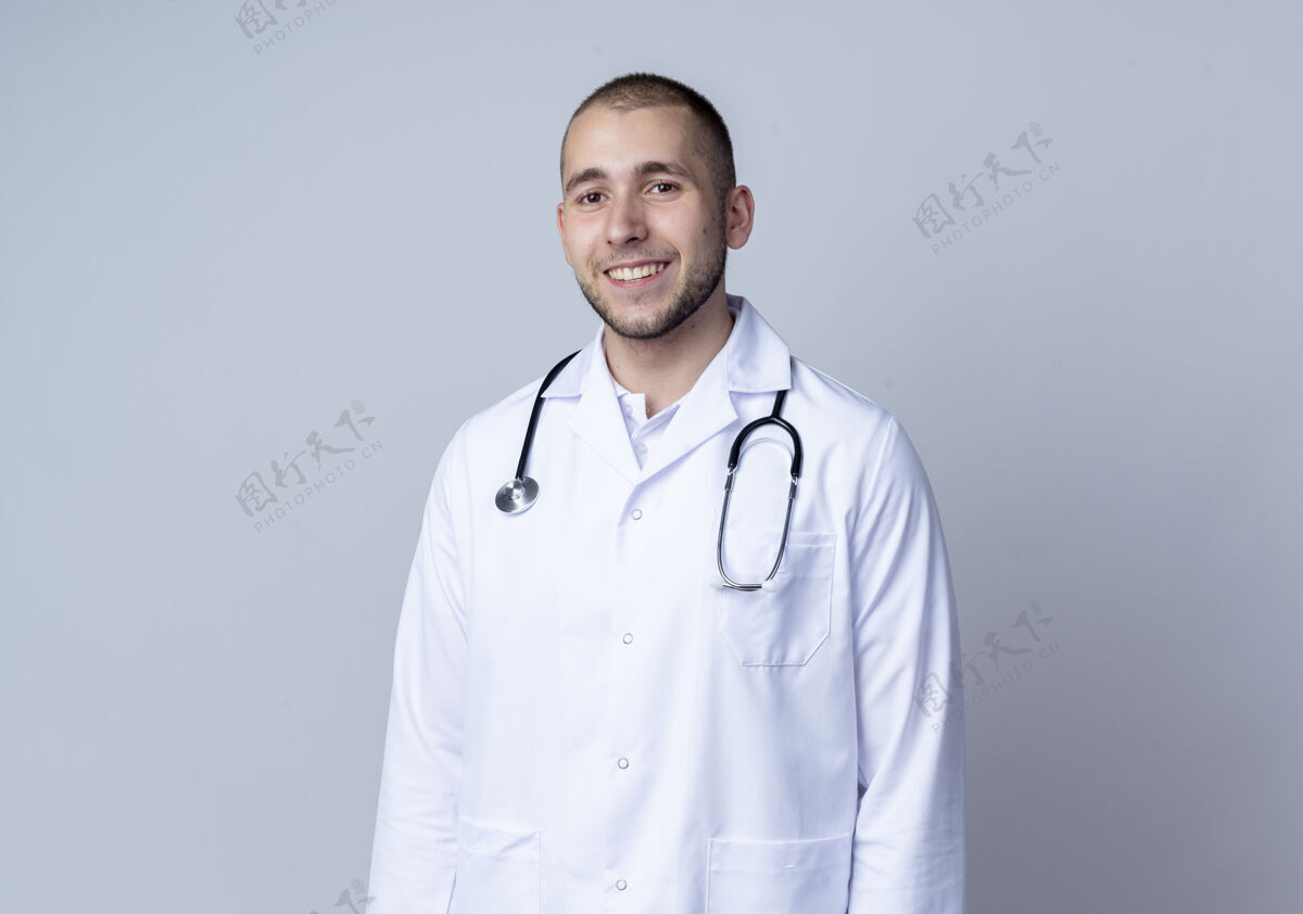 姿势面带微笑的年轻男医生 身穿医用长袍 脖子上戴着听诊器 站在白色的墙上 看着与世隔绝的前方听诊器脸白
