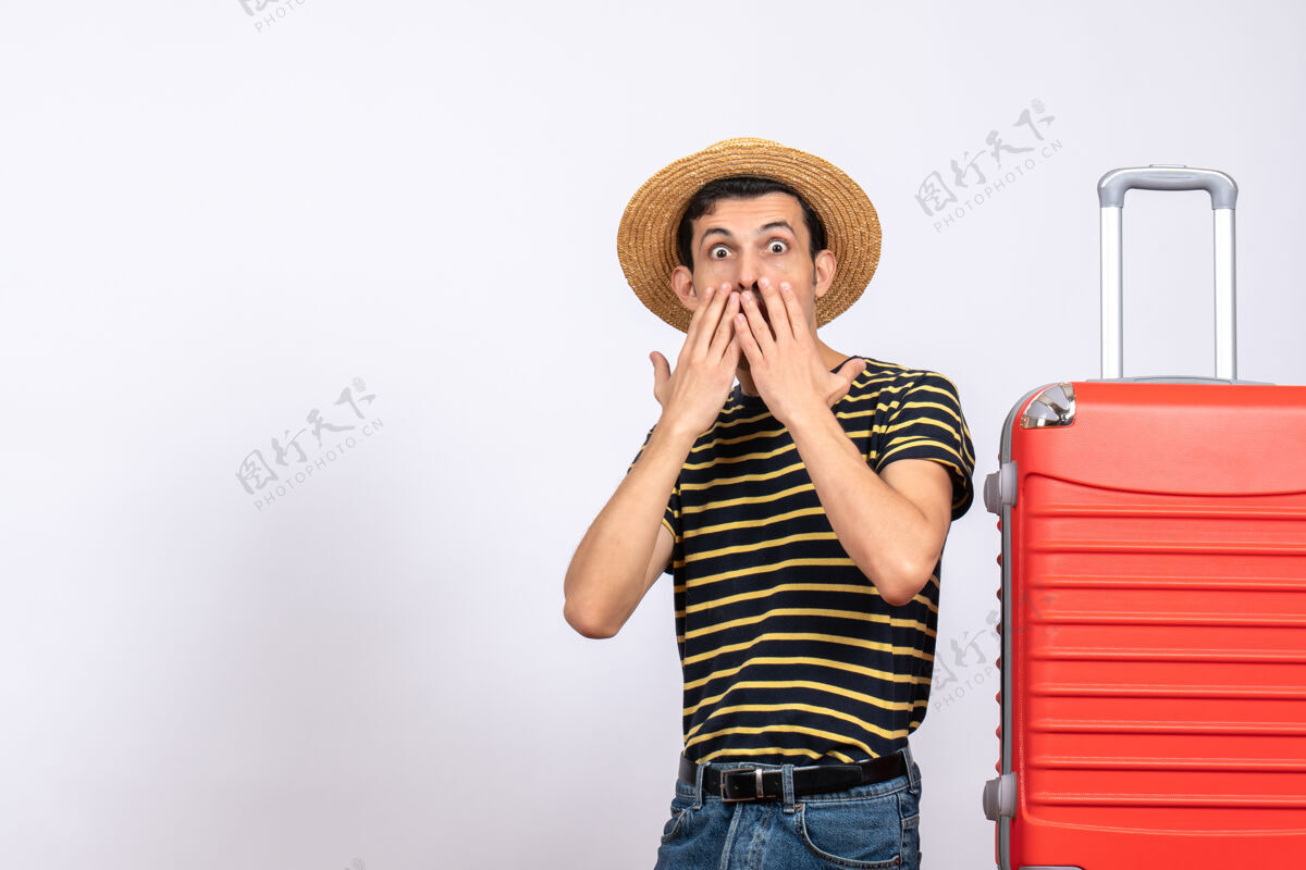 稻草正面图站在红色手提箱旁戴草帽的大眼睛年轻人人眼睛睁大视图