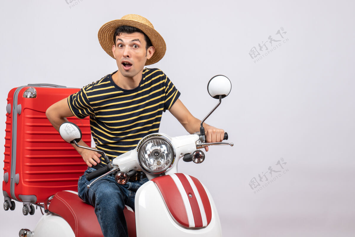 轻便摩托车一个戴着草帽 手放在腰上的年轻人的正视图成人稻草男人