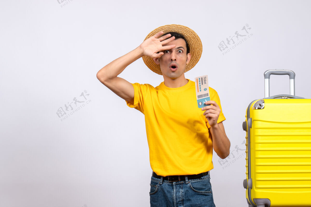 站正面图穿着黄色t恤的年轻人站在黄色手提箱旁纳闷一个人视图