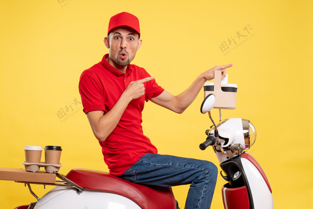 摩托车正面图身穿红色制服的年轻男性信使 黄色背景上有咖啡送货视野黄色