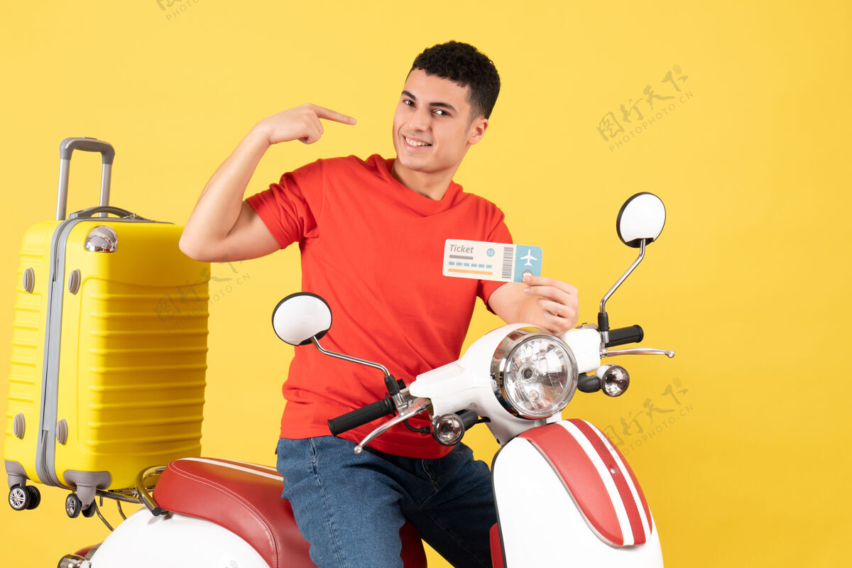 票正面图微笑的年轻人骑着轻便摩托车 手里拿着黄色背景的车票男轻便摩托车景