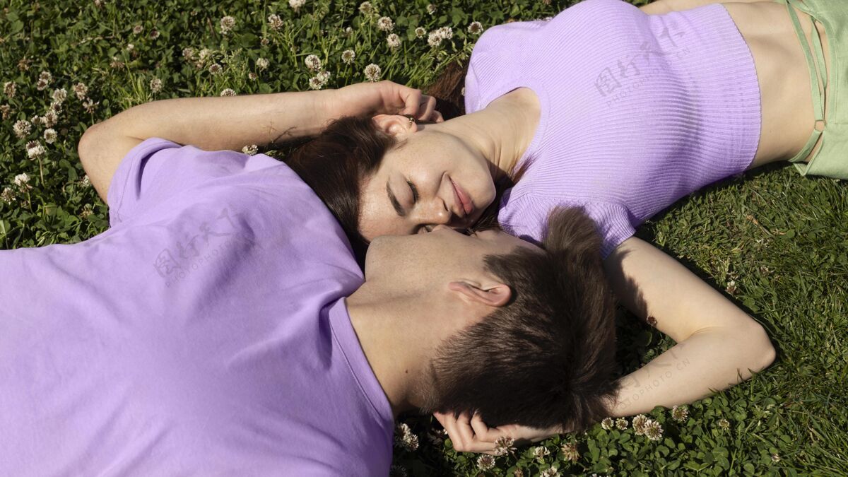 女人可爱的男女朋友躺在草地上女人感情情侣