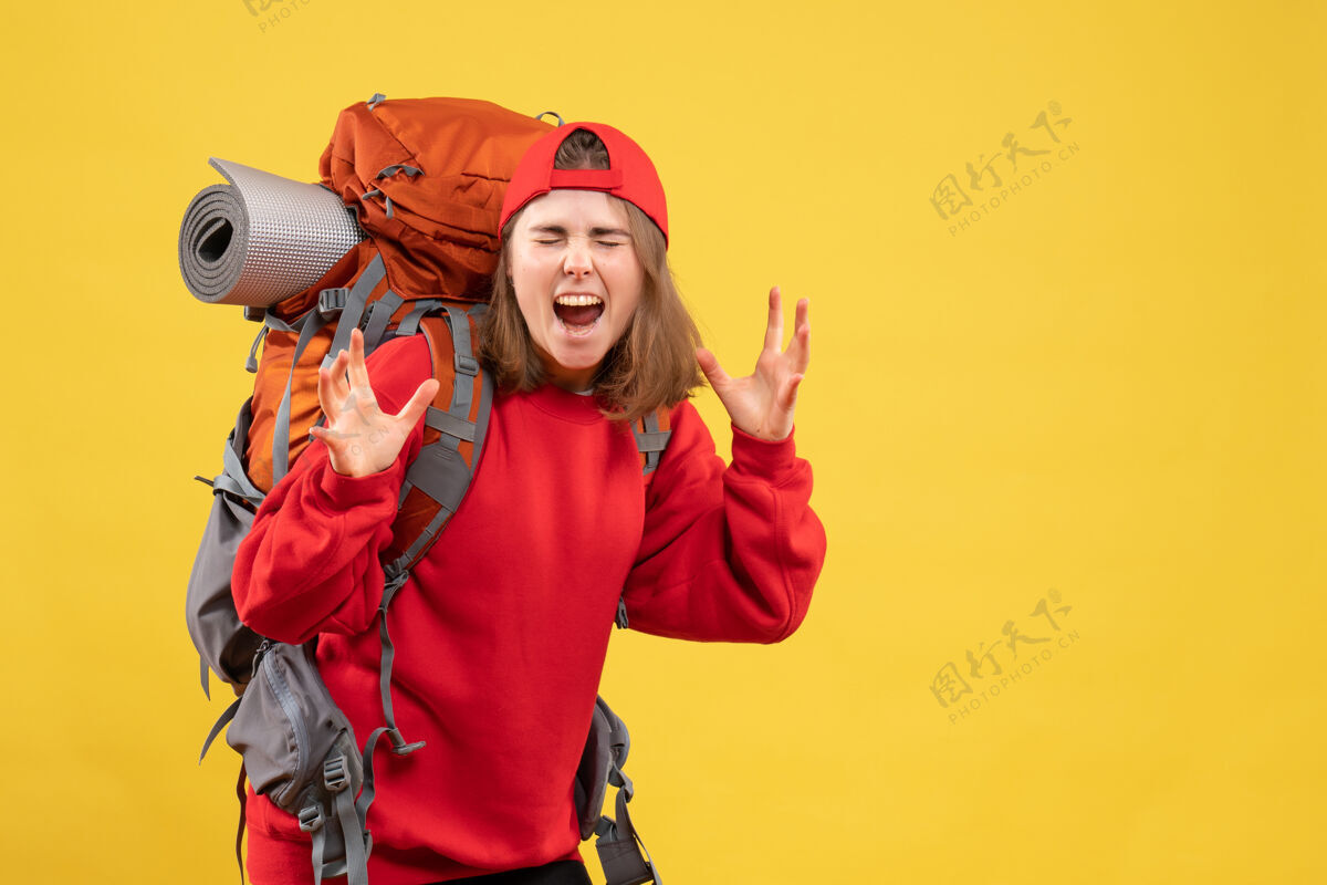 帽子正面是年轻的旅行妇女在红色背包尖叫快乐成人背包