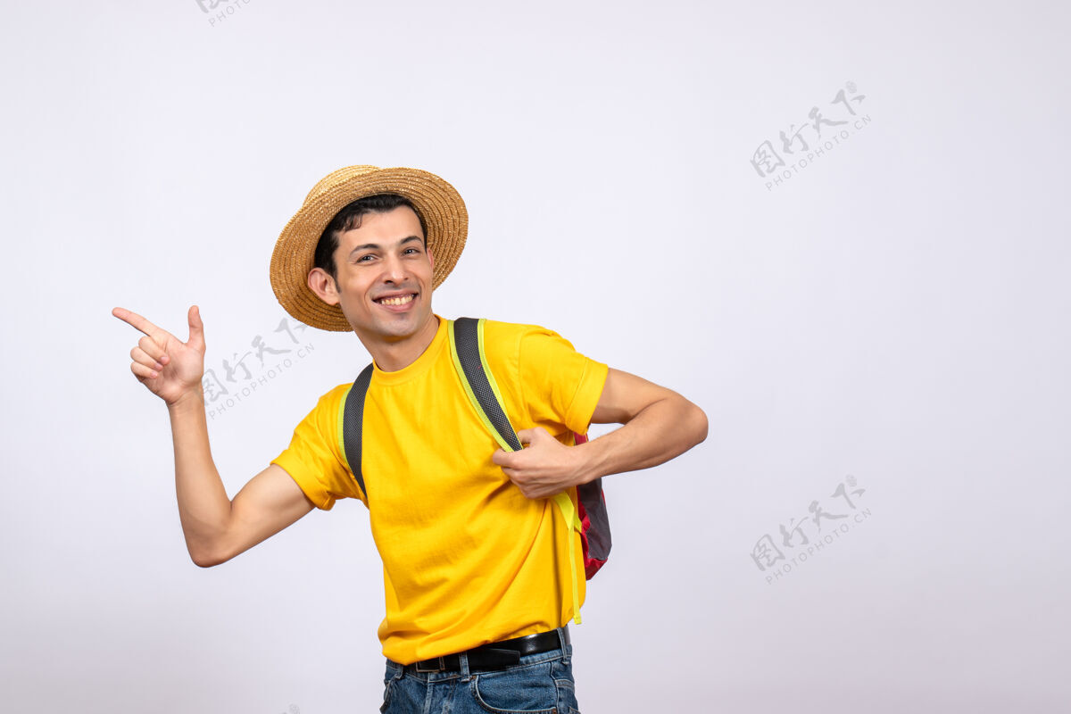 人正面图微笑的年轻人 红色背包 黄色t恤 指着什么欢呼视图T恤