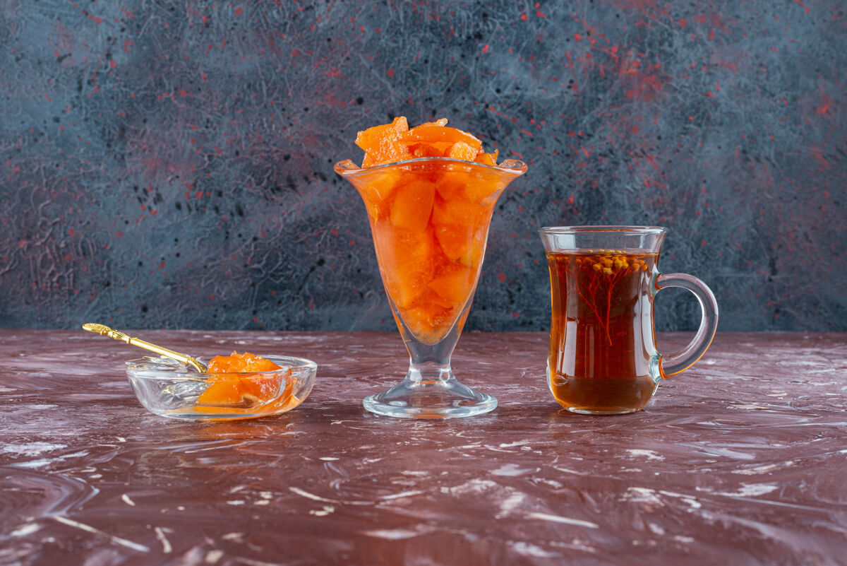 果酱桌上有一杯木瓜酱和一杯红茶水果营养生的