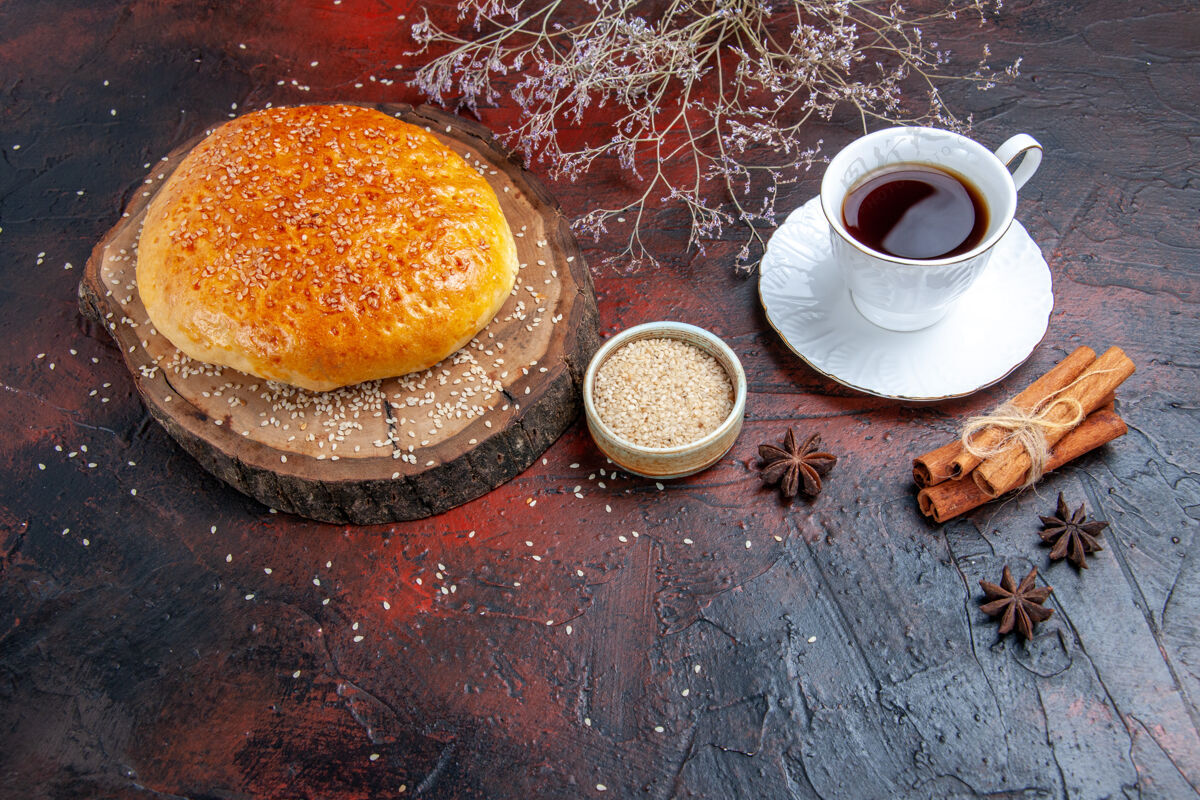 早晨前视图甜甜的烤面包和一杯茶在黑暗的背景棕色食物深色