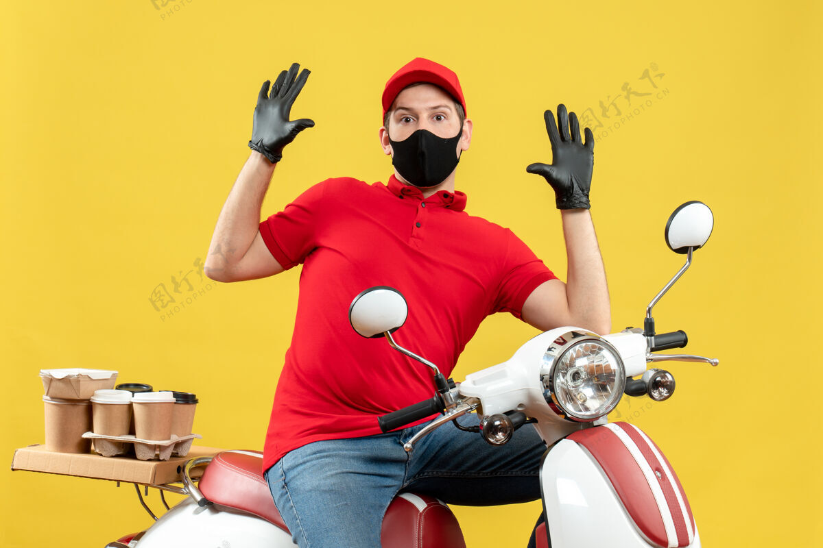 面罩俯视图：快递员身穿红色上衣 戴着帽子手套 戴着医用口罩 坐在滑板车上传递订单 感觉很惊讶手套男性命令