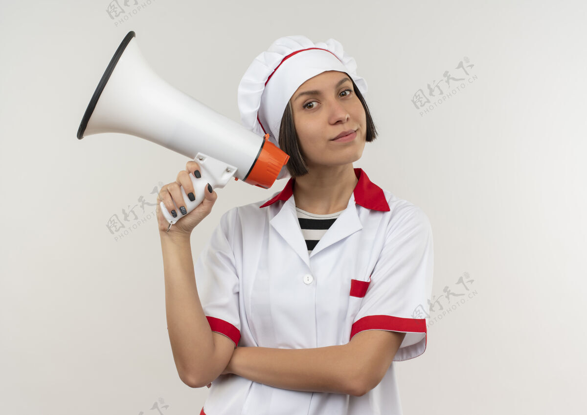 衣服高兴的年轻女厨师在厨师制服举行扬声器隔离在白墙上女性制服白人