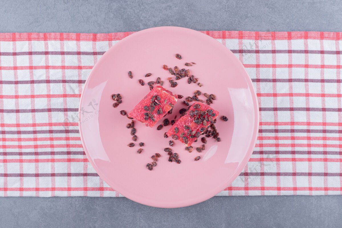 小吃土耳其喜悦拉哈特lokum与开心果和干葡萄干粉红色盘子顶视图自然立方体膳食