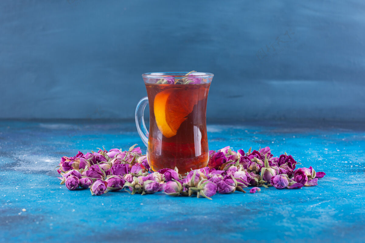 干一杯茶 蓝色的桌子上放着玫瑰有机健康堆