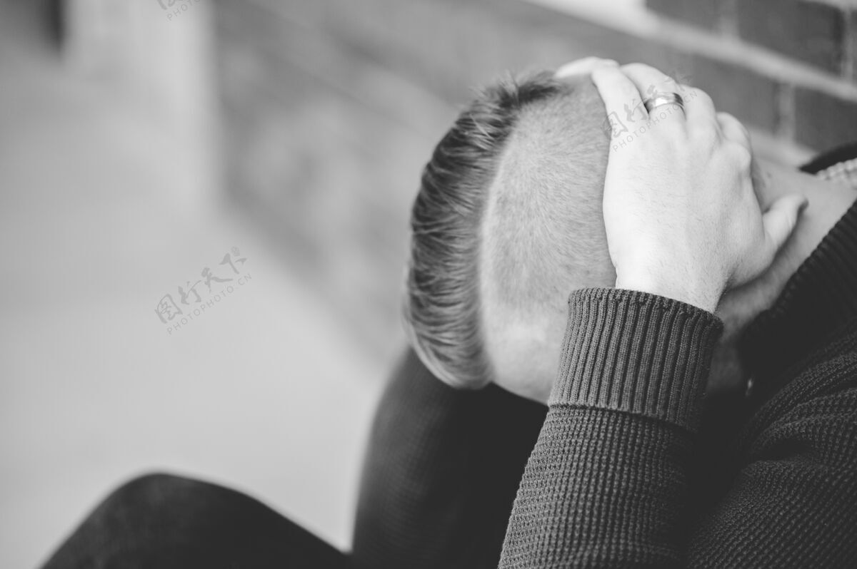 孤独一个男人抱着头坐在地上的灰度照片思考房子担忧