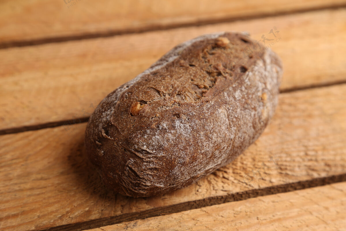 小吃特写镜头自制的棕色面包与坚果片在木制表面种子木材自制