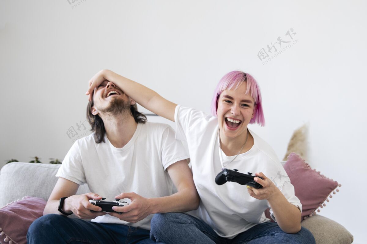 享受可爱的情侣在沙发上玩电子游戏科技数字房子