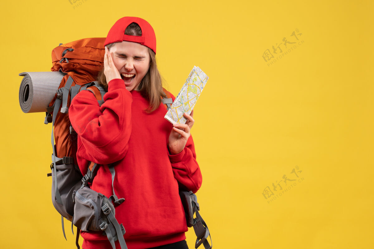 地图正面图愤怒的女背包客拿着旅游地图拿着她的耳朵人男性快乐