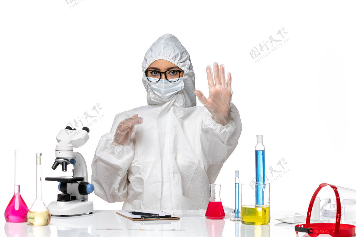诊所前视图穿着特殊防护服的女化学家坐在白色背景化学大流行性冠状病毒的解决方案病毒防护套装
