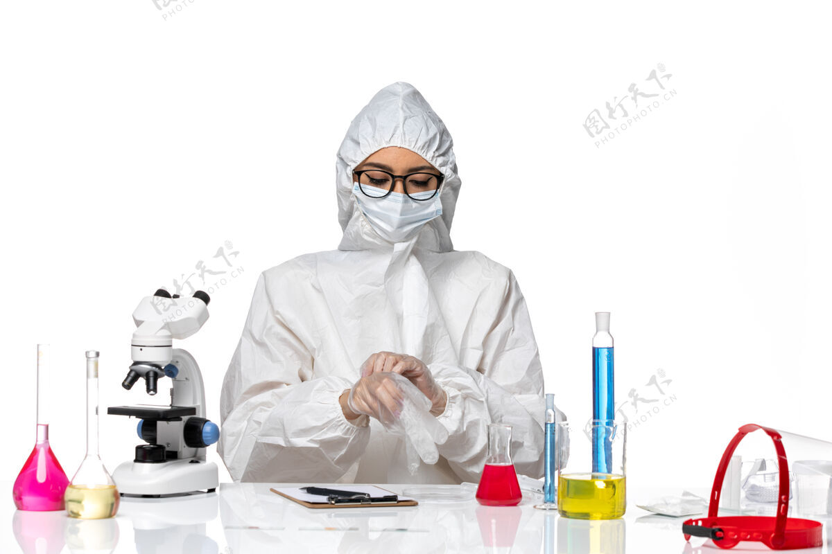 医学前视图穿着特殊防护服的女化学家坐在白色化学大流行性冠状病毒的背景上病毒女化学家医院