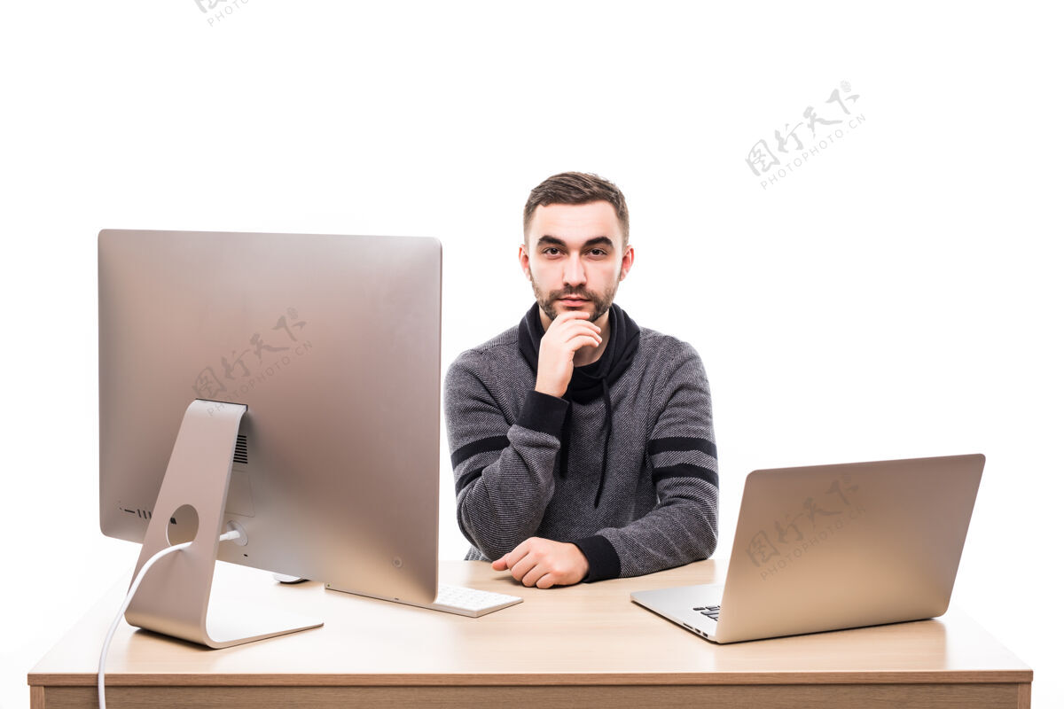 办公室企业家坐在桌边 拿着笔记本电脑和个人电脑 看着隔离在白色屏幕上的摄像机成年人坐着的一个