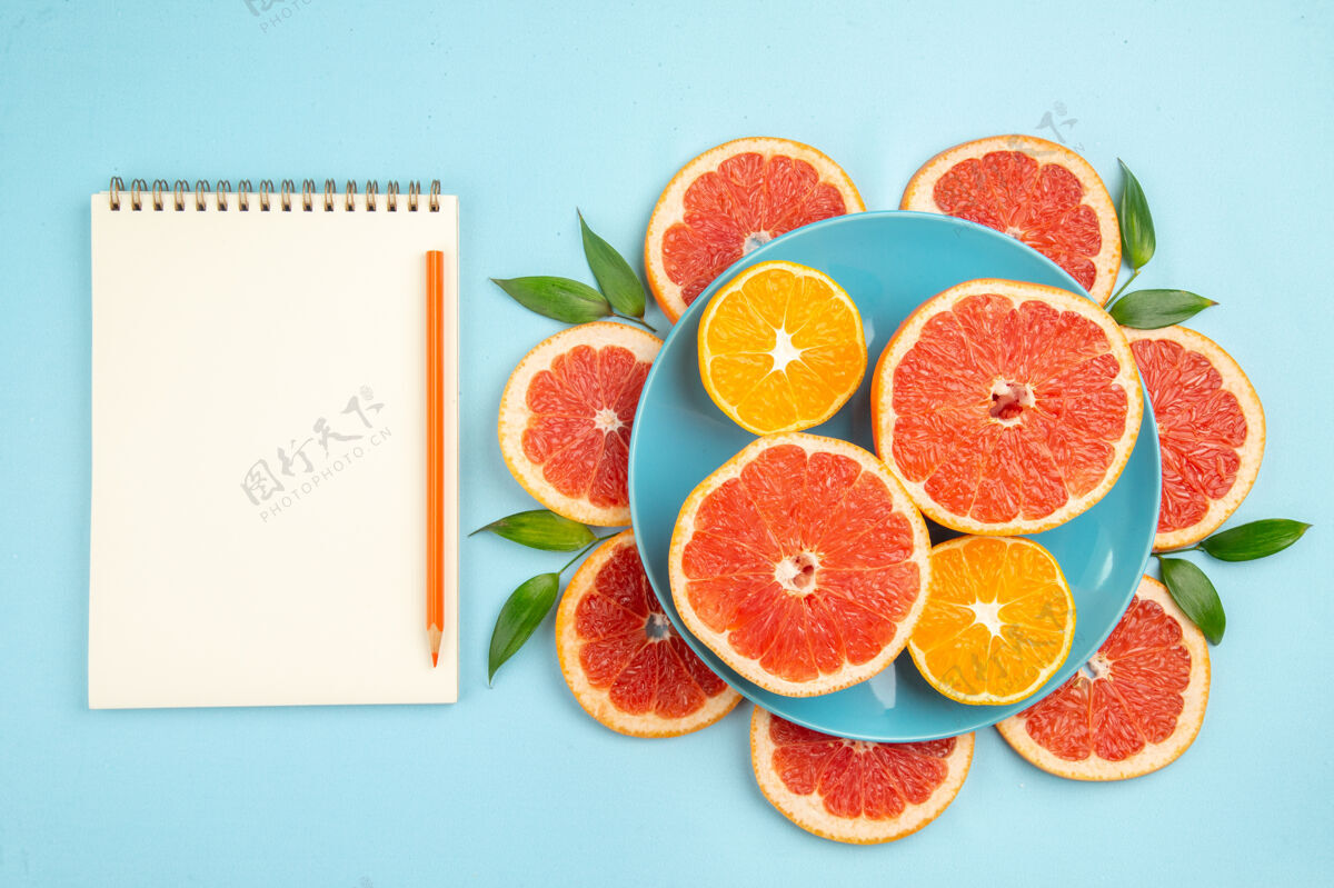 新鲜蓝色表面上美味的葡萄柚水果片俯视图醇香多汁食品