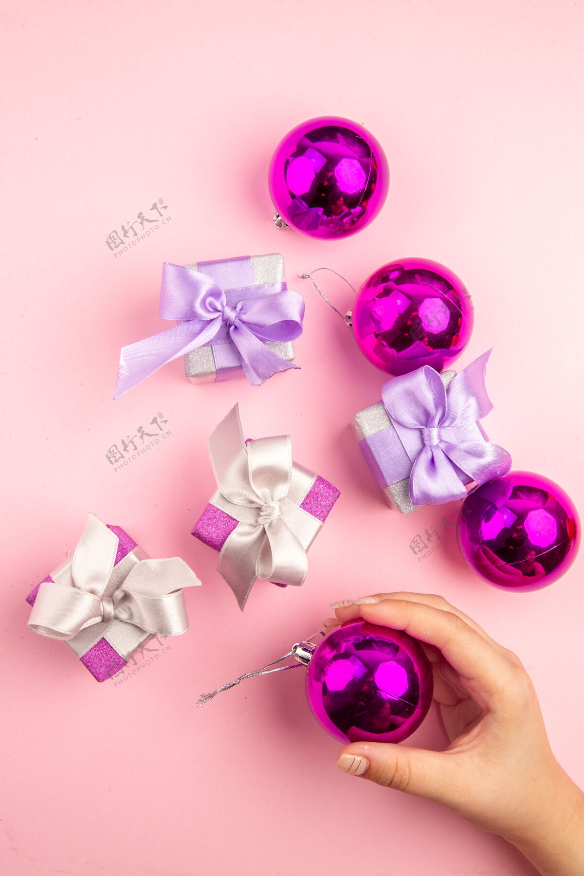 花顶视图的小礼物与圣诞树玩具在粉红色的表面圣诞节春天宝石