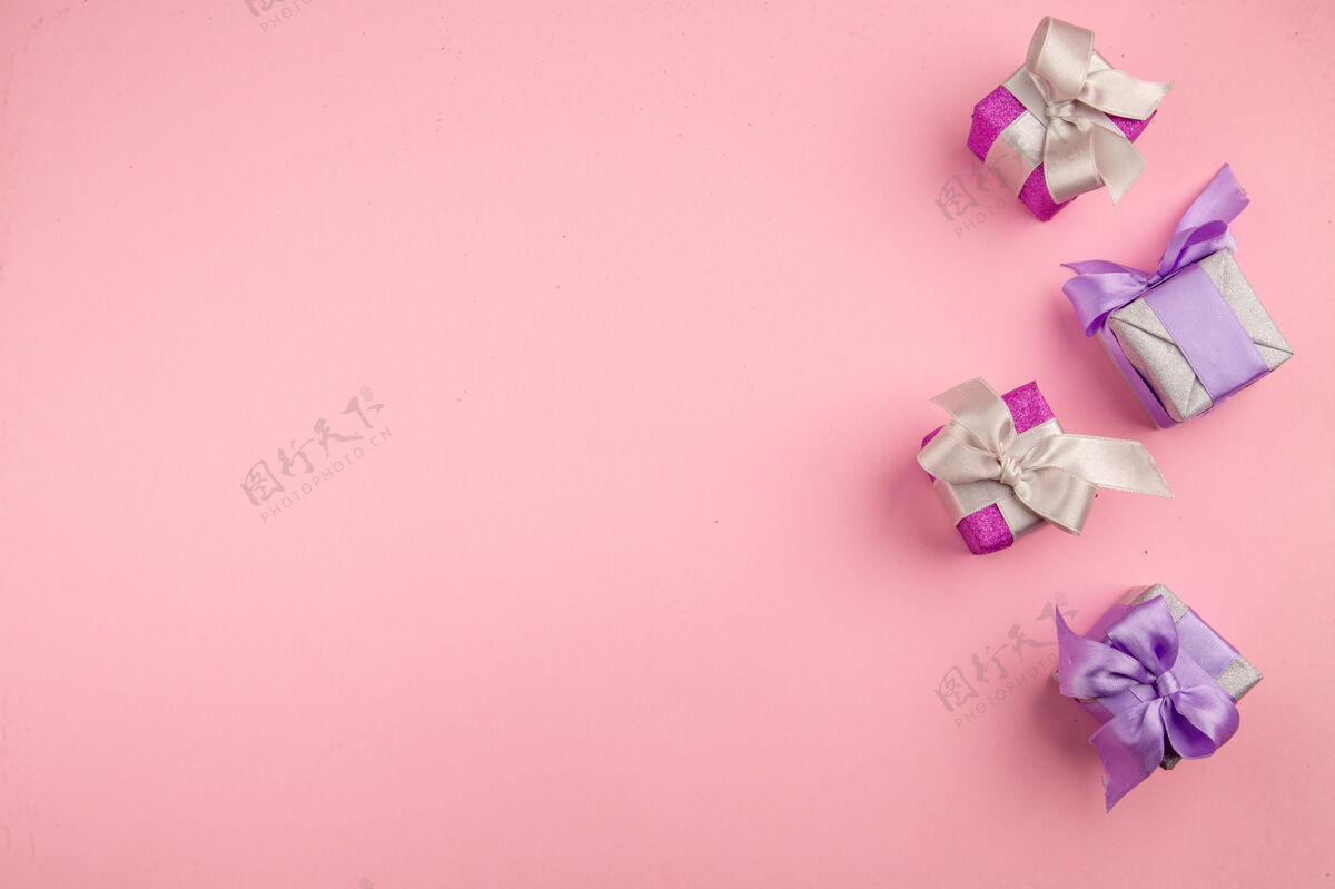 家庭粉红色表面上的小礼物俯视图新年鲜花鲜花