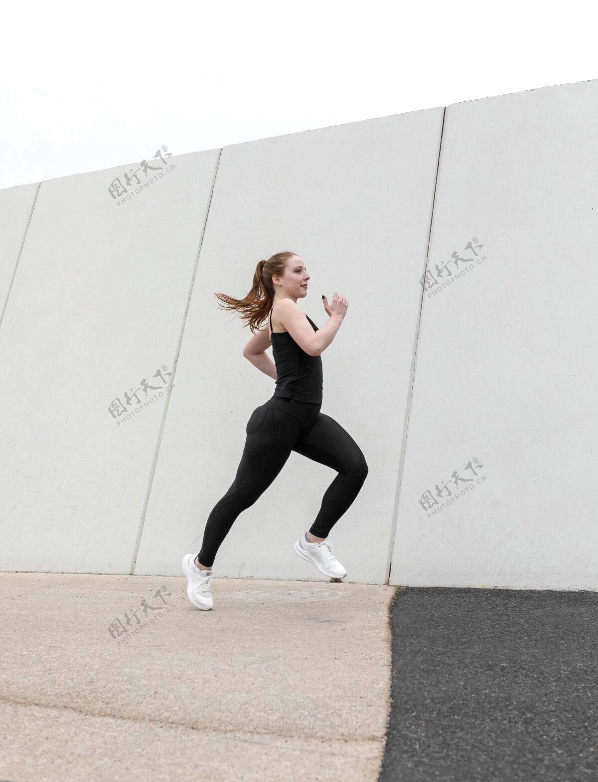 女人穿着运动服在户外锻炼的红发女人运动员健康运动