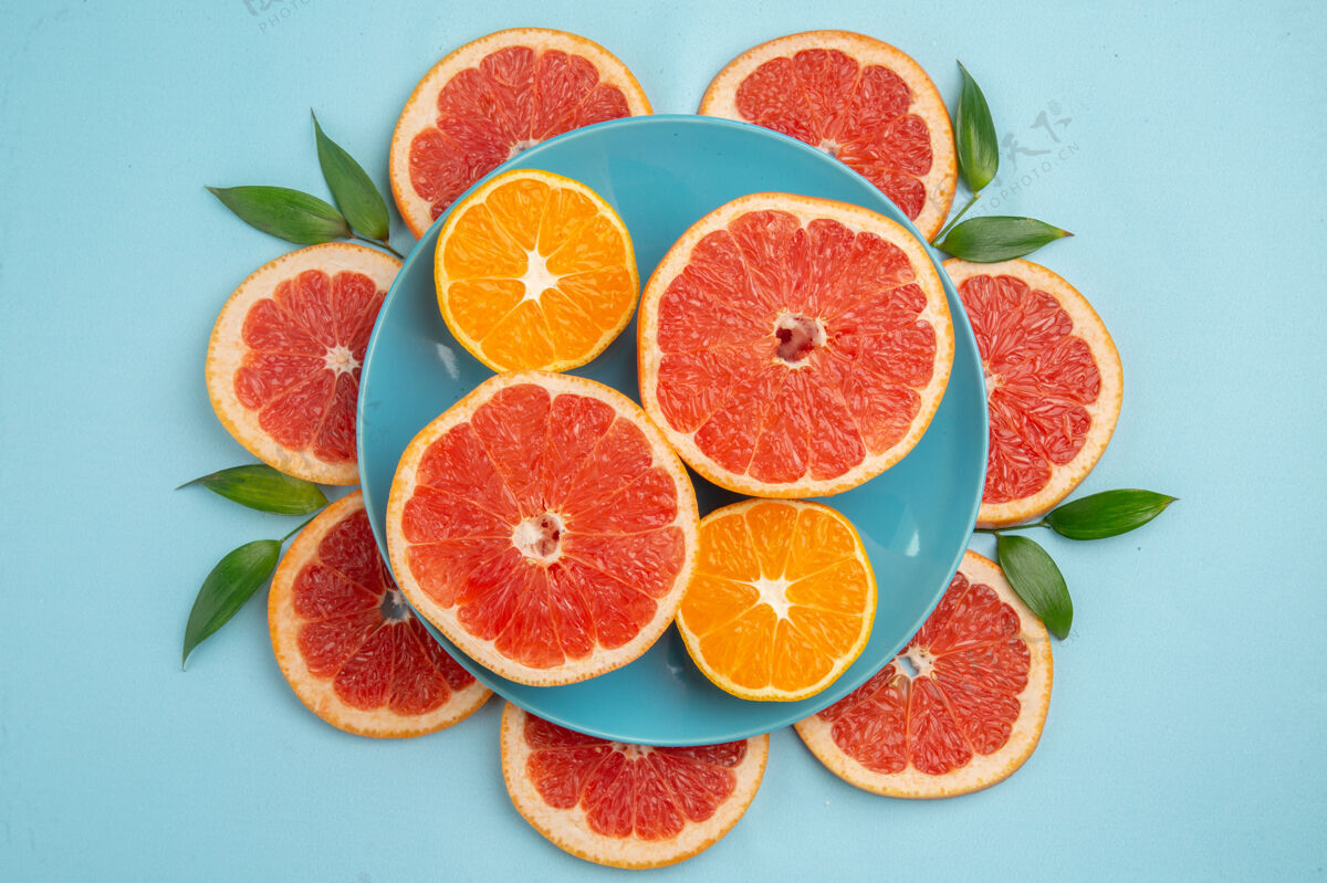 农产品蓝色表面上美味的葡萄柚水果片俯视图切片多汁食用水果