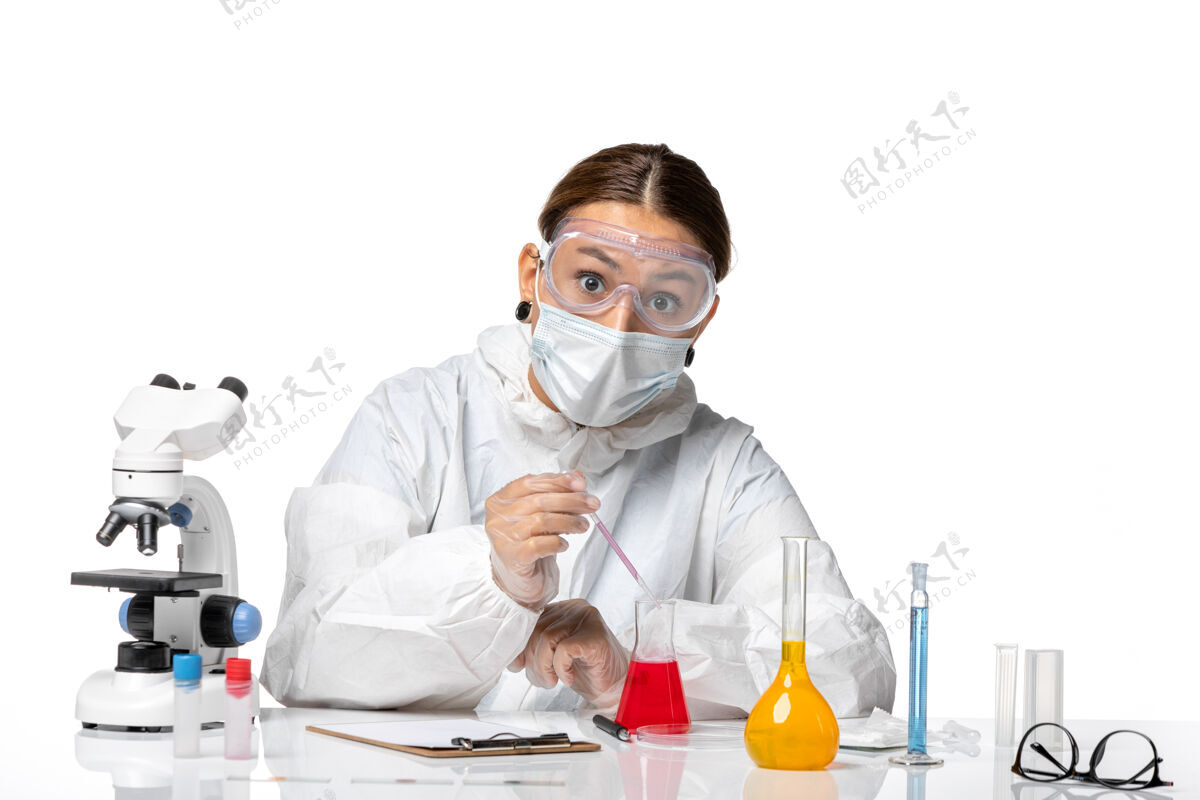 实验室外套前视图穿着防护服 戴着口罩的女医生正在处理白色背景的冠状病毒大流行病毒病毒实验室工作