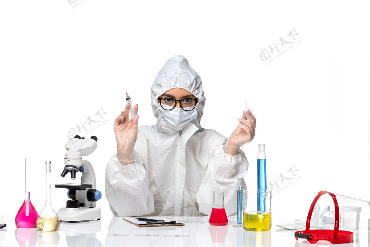 健康正面图身着特殊防护服的女化学家手持白色背景上的注射化学冠状病毒大流行注射药品正面