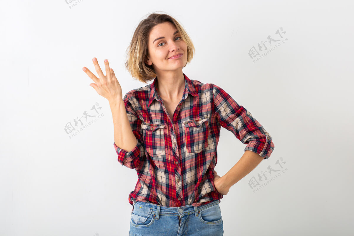 玩耍穿着格子衬衫的年轻有趣的情绪化女人在白色工作室的墙上摆出孤立的姿势 展示姿势有趣手势快乐