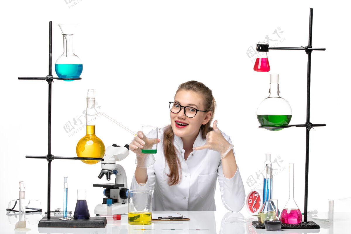 前面前视图穿着医疗服的女化学家拿着白色背景上的装有溶液的烧瓶化学大流行健康病毒烧杯瓶子罐子