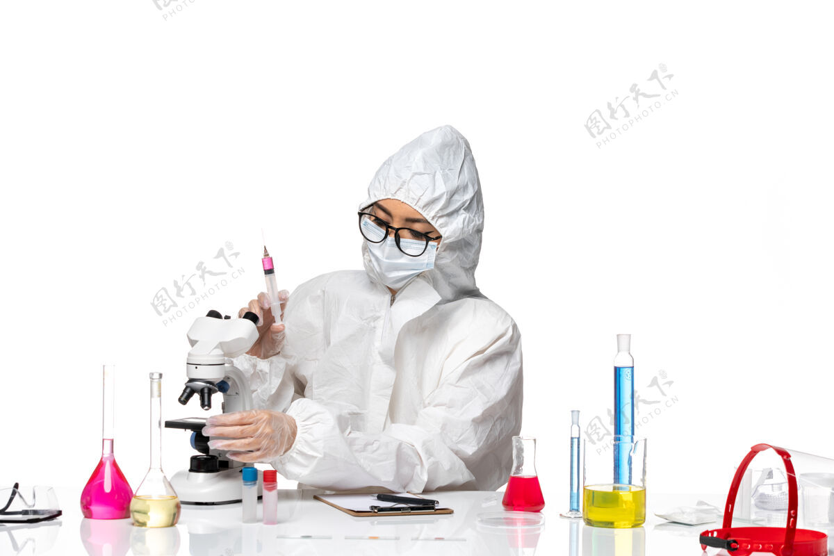 防护前视图穿着特殊防护服的女化学家在白色背景上注射化学病毒实验室视图医疗医生