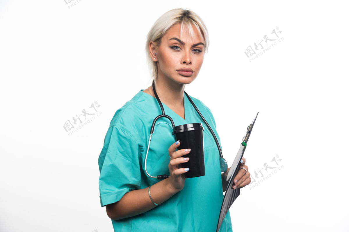 制服女医生在白墙上喝咖啡休息拿着文件夹医院