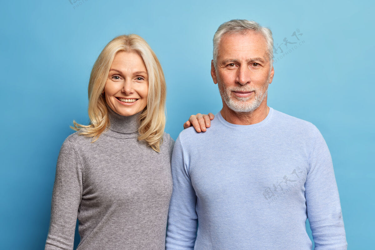 高领毛衣成熟情侣的肖像站在对方旁边 直视镜头有满意的表情关系退休爱情