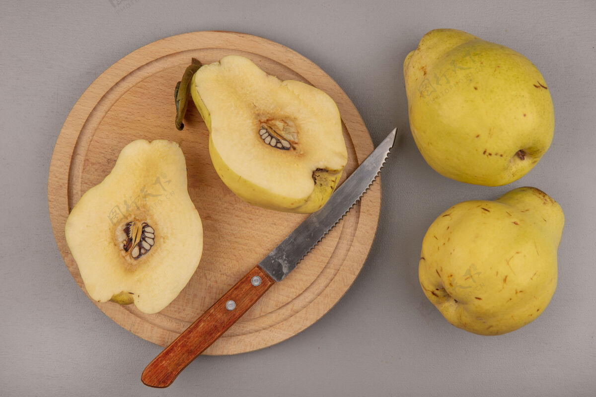 灰色在一个木制的厨房板上用刀将新鲜的一半的木瓜与整个木瓜隔离 俯视图顶部食谱刀
