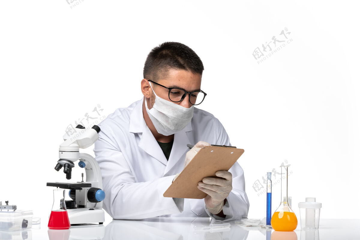 医学前视图穿着白色医疗服的男医生在空白处写笔记健康笔记健康专业