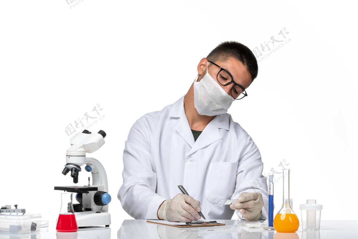 医生前视图穿着白色医疗服的男医生在一个浅白色的空间里工作和写作医学浅白色大流行